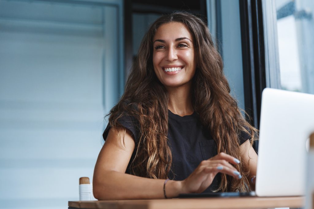 Woman smiling sitting at laptop